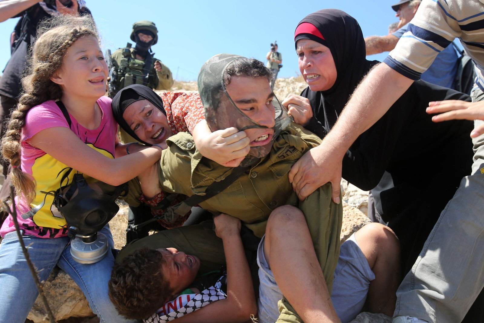 A Palestinian girl on the left is detained during a land confrontation in the West Bank